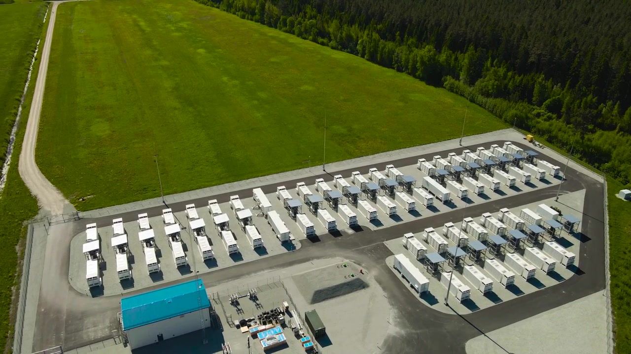 Luftperspektiv af et storstilet BESS (Battery Energy Storage System), et batterienergilagringsanlæg, med containere, der lagrer strøm til elnettet, der understøtter overgangen til bæredygtige og vedvarende energikilder