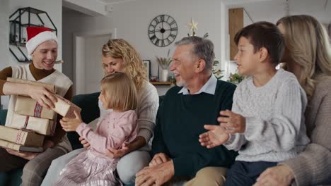 big caucasian family receiving christmas gifts from young uncle.