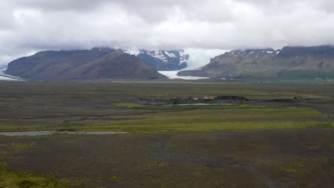 Iceland-glacier-wide-shot-with-clouds-and-drone-video-moving-up