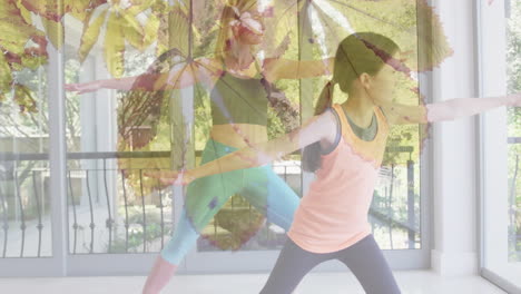 animation of leaves over happy caucasian woman with her daughter doing yoga