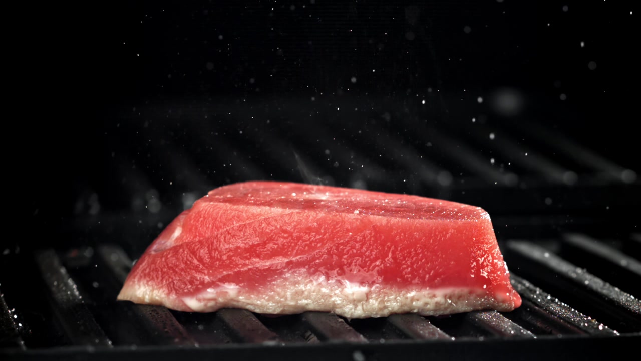 Rå tunbøf krydres på en varm grill