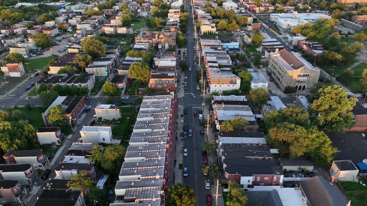 Slow drone flight over Main Street of American town with townhouses and historic row homes. Sunset time in Camden, New Jersey. Summer day in America. Roofing flight. Quiet scene
