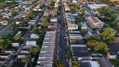 slow drone flight over main street of american town with townhouses and historic row homes. sunset time in camden, new jersey. summer day in america. roofing flight. quiet scene