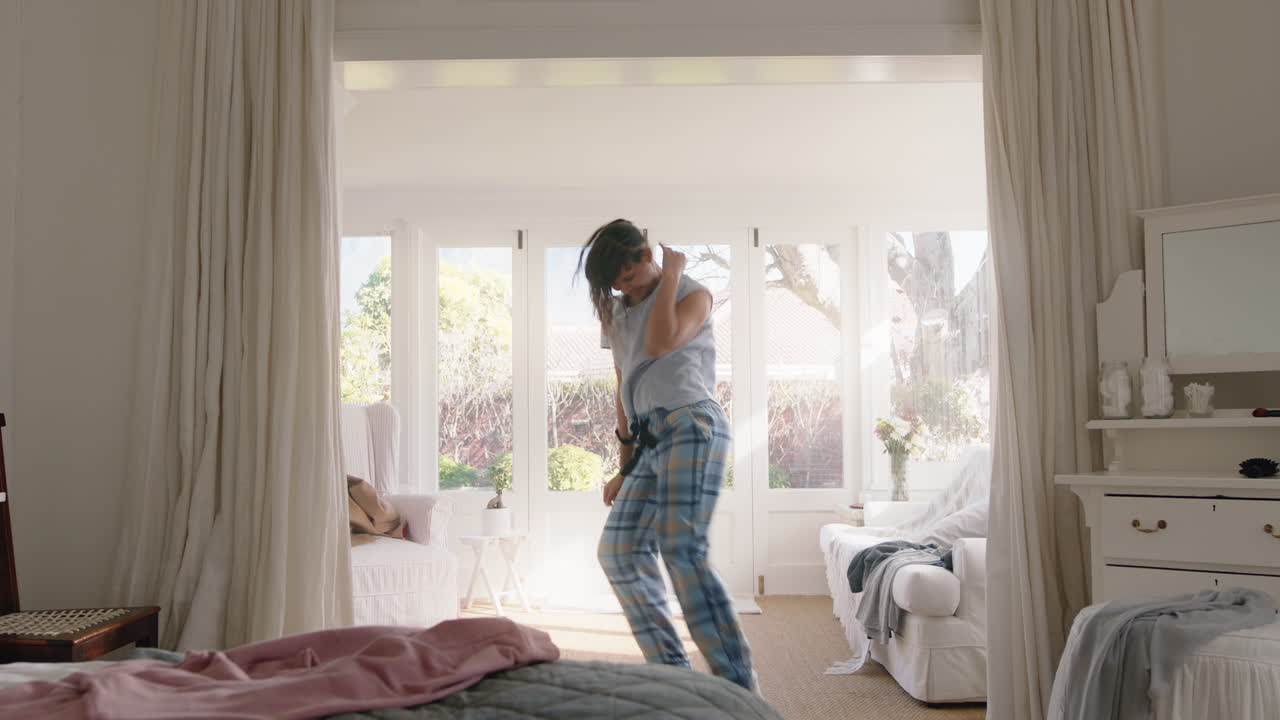 행복한 십대 소녀가 침실에서 음악에 맞춰 춤을 추고 주말 아침을 즐기고 즐겁게 축하하고 집에서 피자마를 입고 무관심한 생활 방식을 즐기고