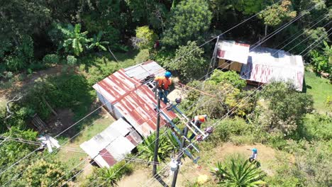 trabajadores que extienden el cable de protección para las líneas eléctricas dentro de un área rural