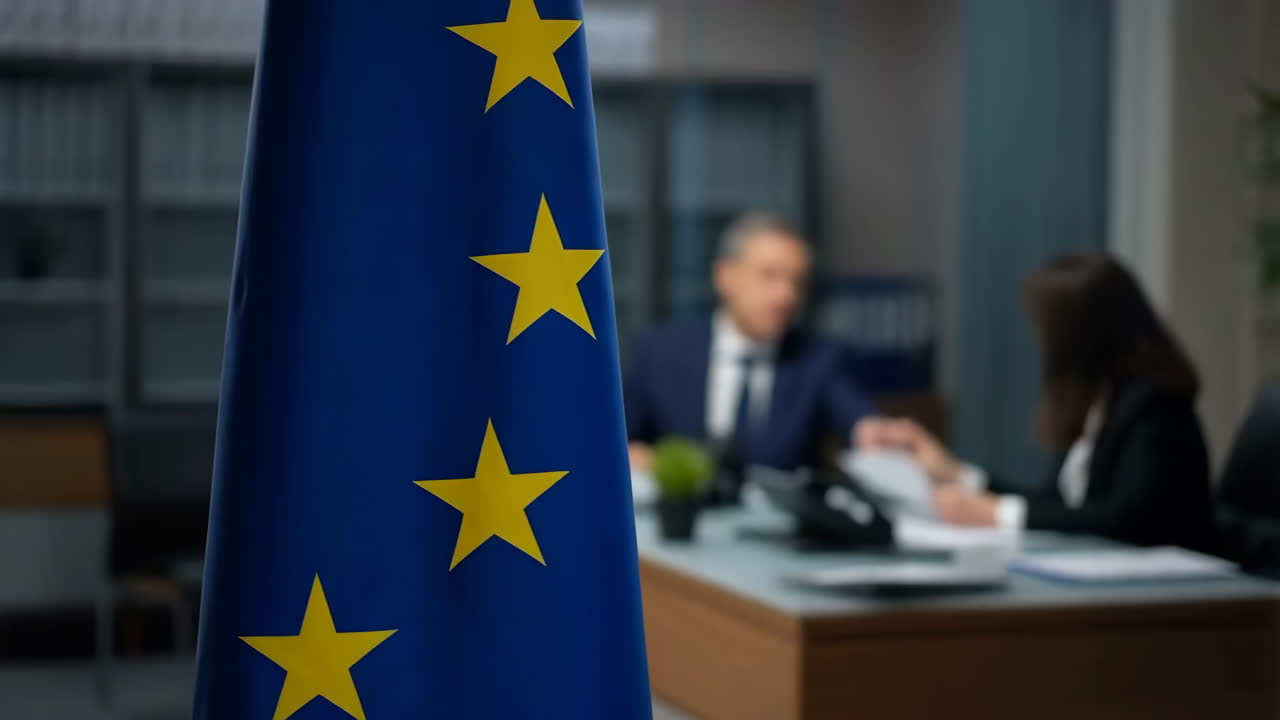 Bandiera dell'Unione Europea in un ambiente d'ufficio con persone sfocate sullo sfondo