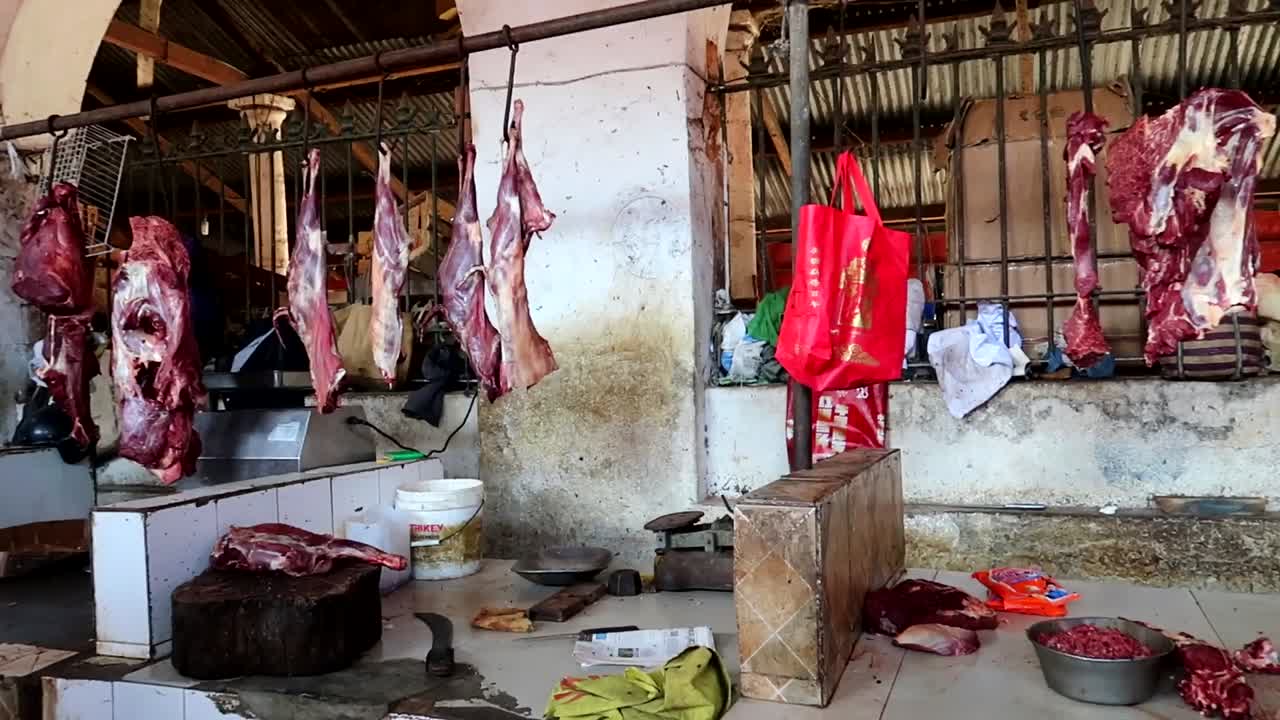 panorámica derecha revelando carne colgada lista para ser vendida en el mercado africano darajani