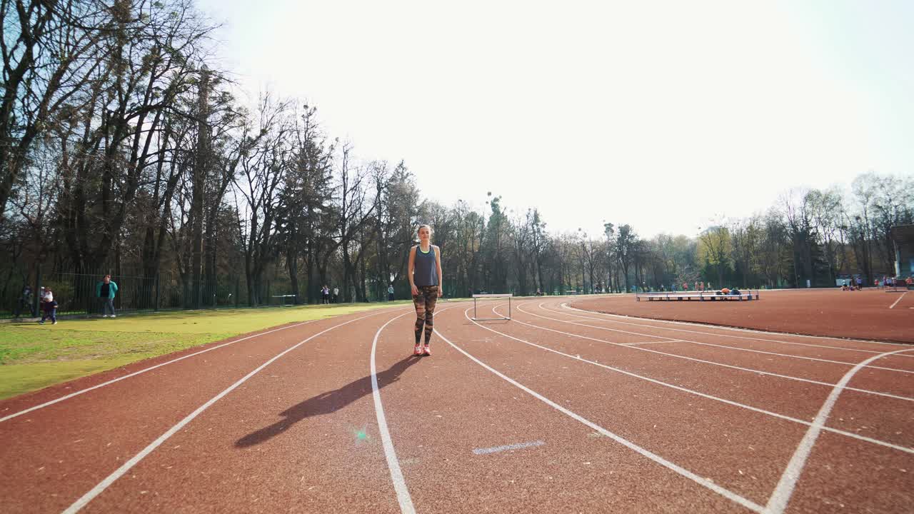 Athletic woman running on track. Track runner putting his hands at starting line. Healthy fitness lifestyle.