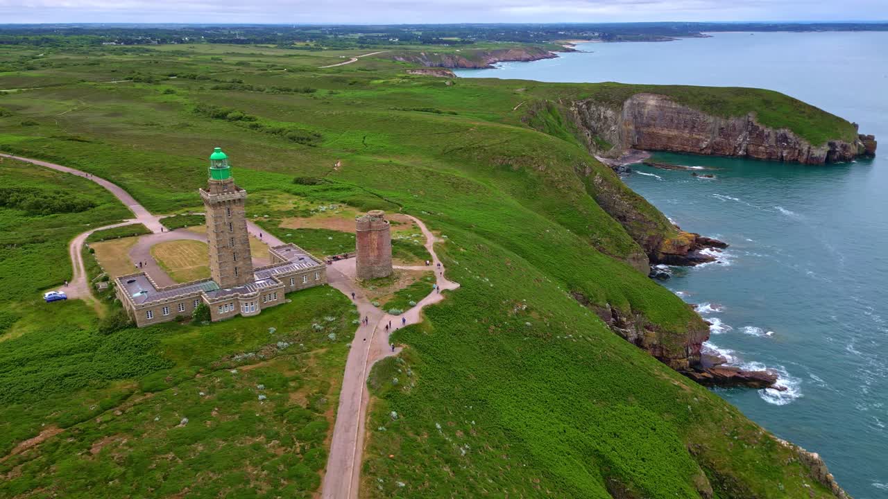Backside view of the Cap Fréhel peninsula lighthouse with cliffside road on drone movement, Côtes-d'Armor, Brittany, France.