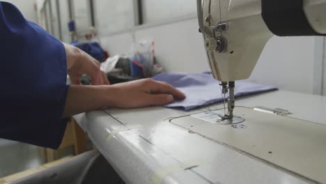 worker cutting the sewing machine thread
