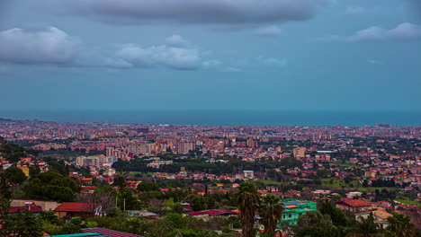 Tiro-De-Lapso-De-Tiempo-De-Nubes-Oscuras-Volando-Sobre-La-Ciudad-De-Palermo-Con-Paisaje-Marino-En-El-Fondo---Italia,-Sicilia