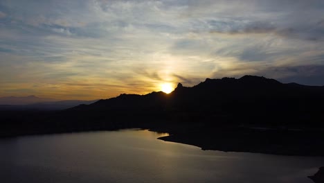 Aerial-shot-of-a-colorful-golden-hour-sky-and-a-reflection-in-a-lake