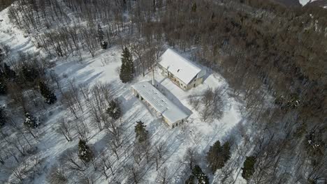 aerial 4k drone footage of a old abandoned millitary complex on the top of the mountain in the winter time