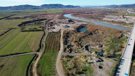 ruined land with pits filled with waste after being used for sand mining near shkumbini river in albania