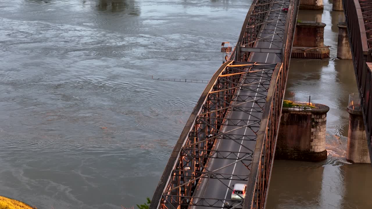 Slow motion Aerial orbit of the historic iron Ponte di Ferro bridge connecting Lombardy and Emilia-Romagna, with its lattice steel structure crossing the wide Po River