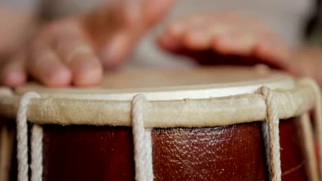 cerca de las manos de un hombre tocando un tambor.