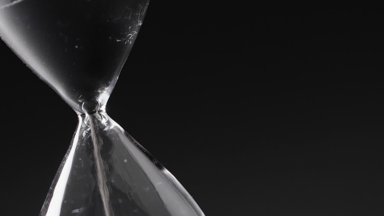 Video di clessidra con sabbia che scorre, spazio per il testo su sfondo nero