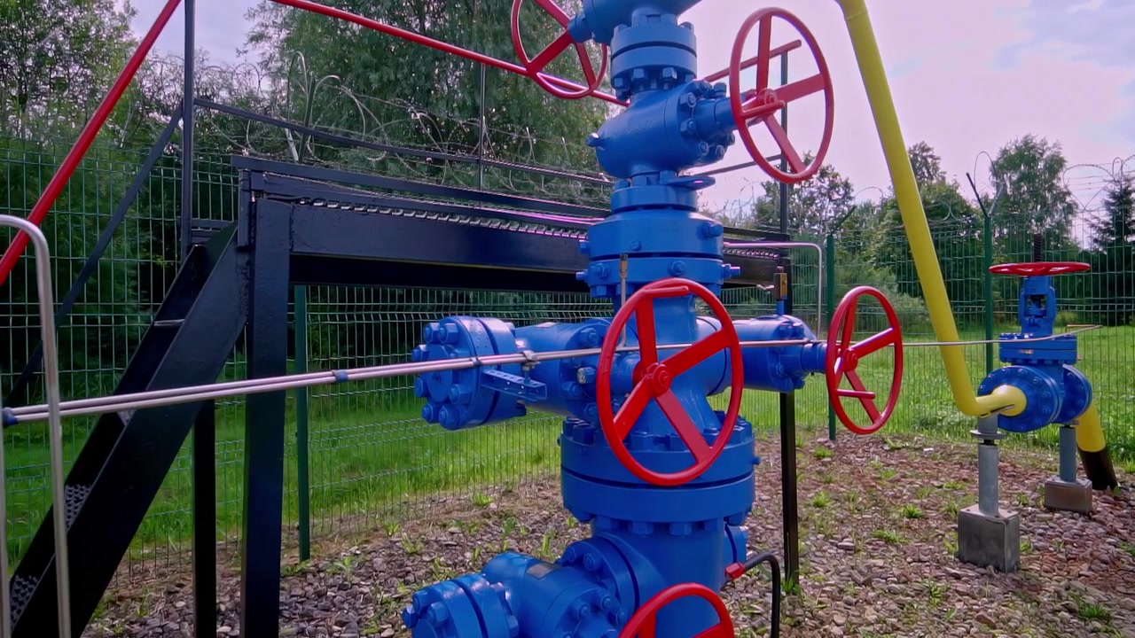 Vista panoramica a mano libera, attrezzatura con valvole di servizio blu, ruote di controllo rosse, tubazioni e un manometro. Utile per temi di ingegneria, infrastrutture, gas, acqua e manutenzione