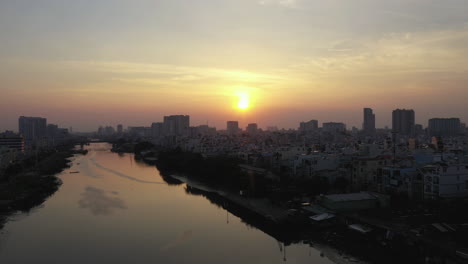 tiro de drone al atardecer mirando a lo largo de un canal en la ciudad de ho chi minh vietnaam sobre el reflejo del espejo en el agua