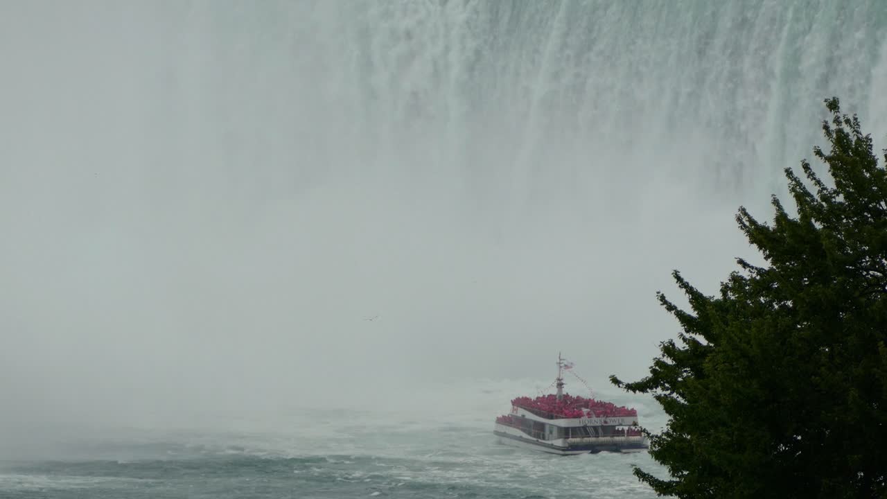Niagara Falls tour boat near waterfall cascade spray mist, popular tourism