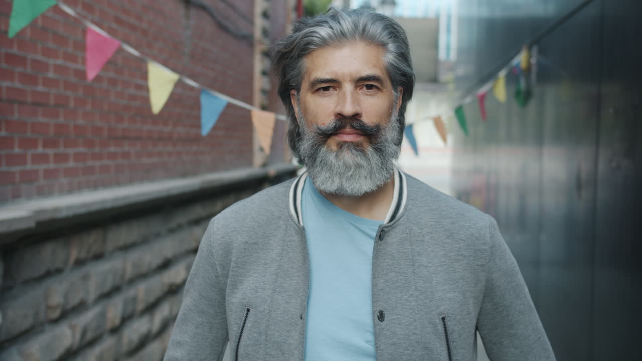 Older man with gray hair and beard in an alleyway