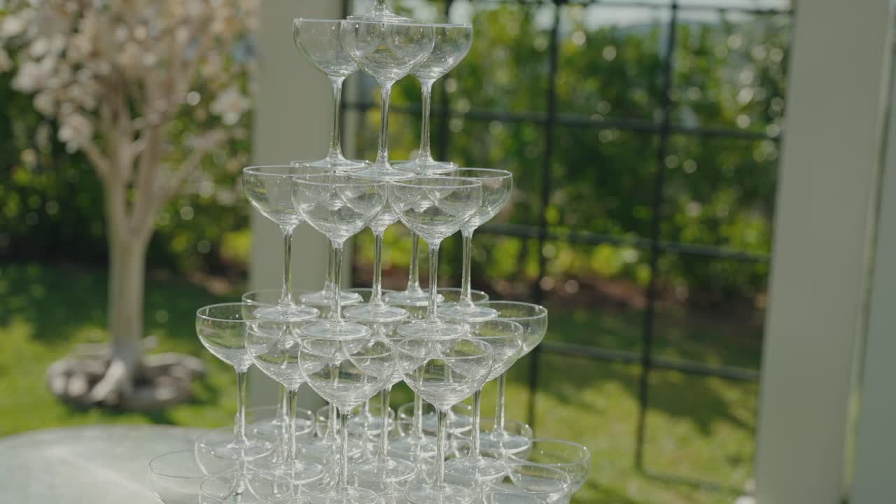 Piramide di calici da champagne vuoti disposti all'aperto per un evento festivo