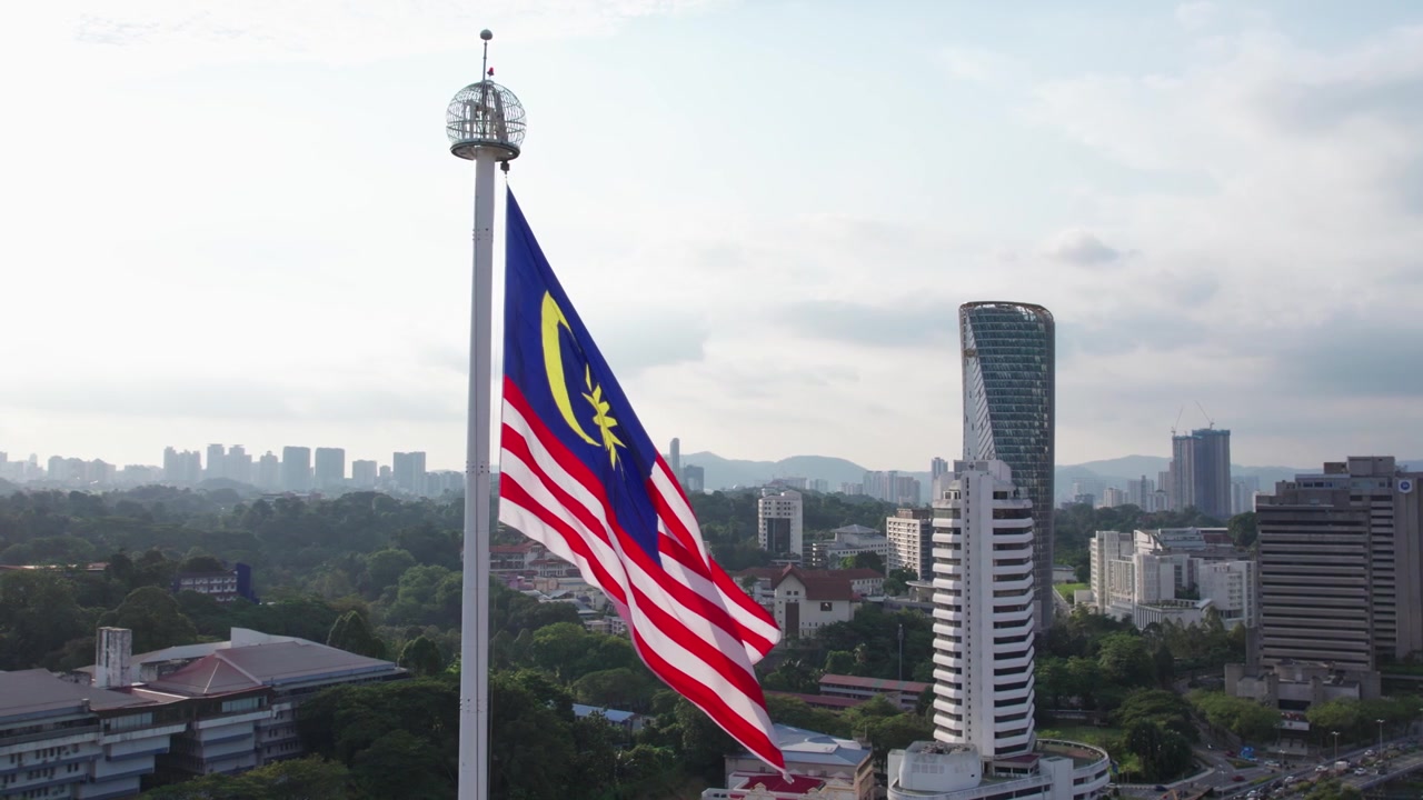 Riprese drone lente che mostrano la bandiera della Malesia sventolare al rallentatore