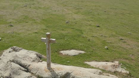 Hochwertiges-Filmmaterial-Mit-Einer-Drohne,-Die-über-Ein-Weißes-Kalksteinkreuz-Mit-Einem-Hauch-Von-Goldbraunen-Flechten-Fliegt,-Das-An-Einem-Wintermorgen-In-Avila,-Spanien,-Auf-Einem-Großen-Weißen-Granitboot-Auf-Einer-Grünen-Wiese-Sitzt