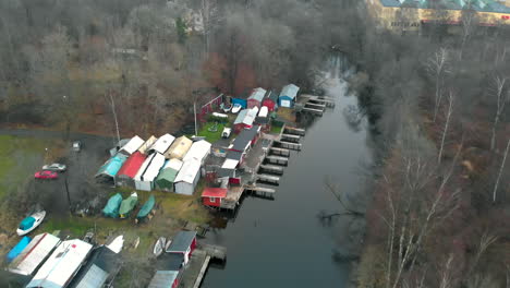 birds view of tiny river with sheds and boats