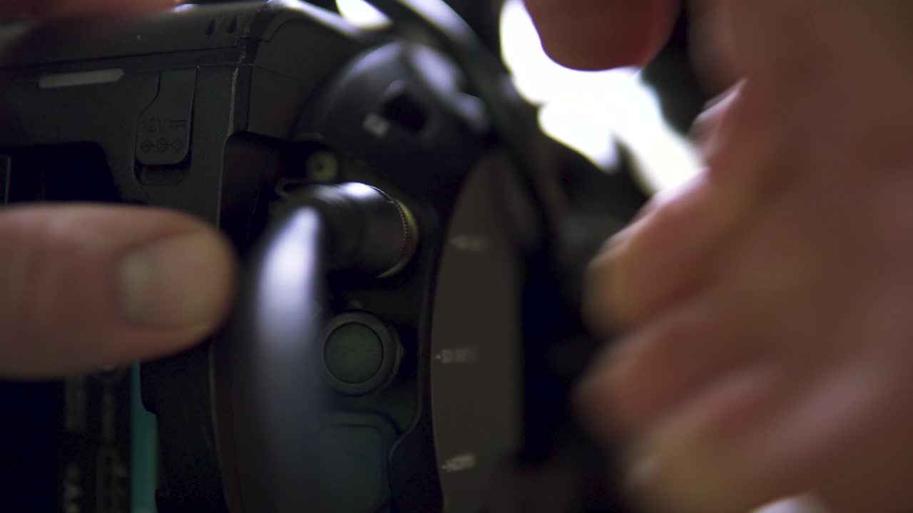 A camera operator changes cables on the camera, showcasing the technical side of video production, equipment handling, and behind-the-scenes work of a professional film crew