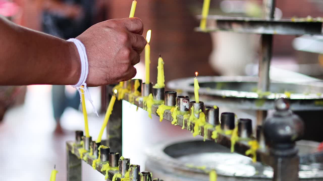 persona encendiendo velas en un templo