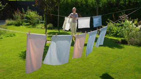 woman hanging clothes to dry in garden