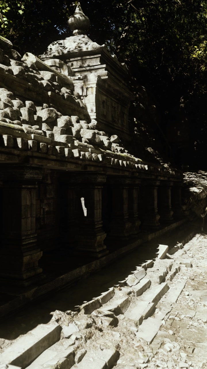 Ancient temple facade illuminated by single sunbeam amidst trees