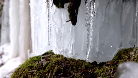 slow motion water dropping down icicles