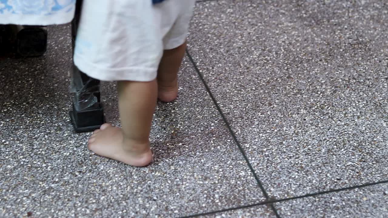 niño pequeño dando pequeños pasos con la ayuda del borde de la cama en el interior