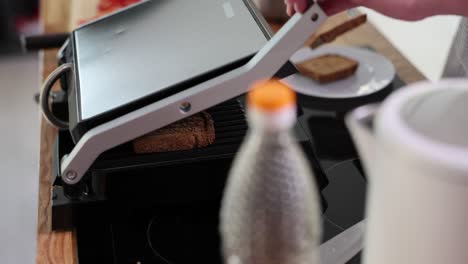 person toasting bread on an electric grill for breakfast