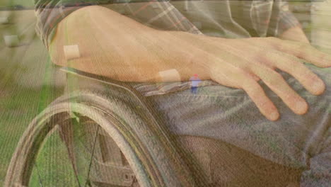 person's hand resting on wheelchair armrest with grassy field animation overlay