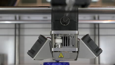 vista de cerca de la impresora 3d en proceso hace piezas para equipos con plástico azul