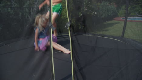 niños jugando en trampolín vistos a través de la red de seguridad