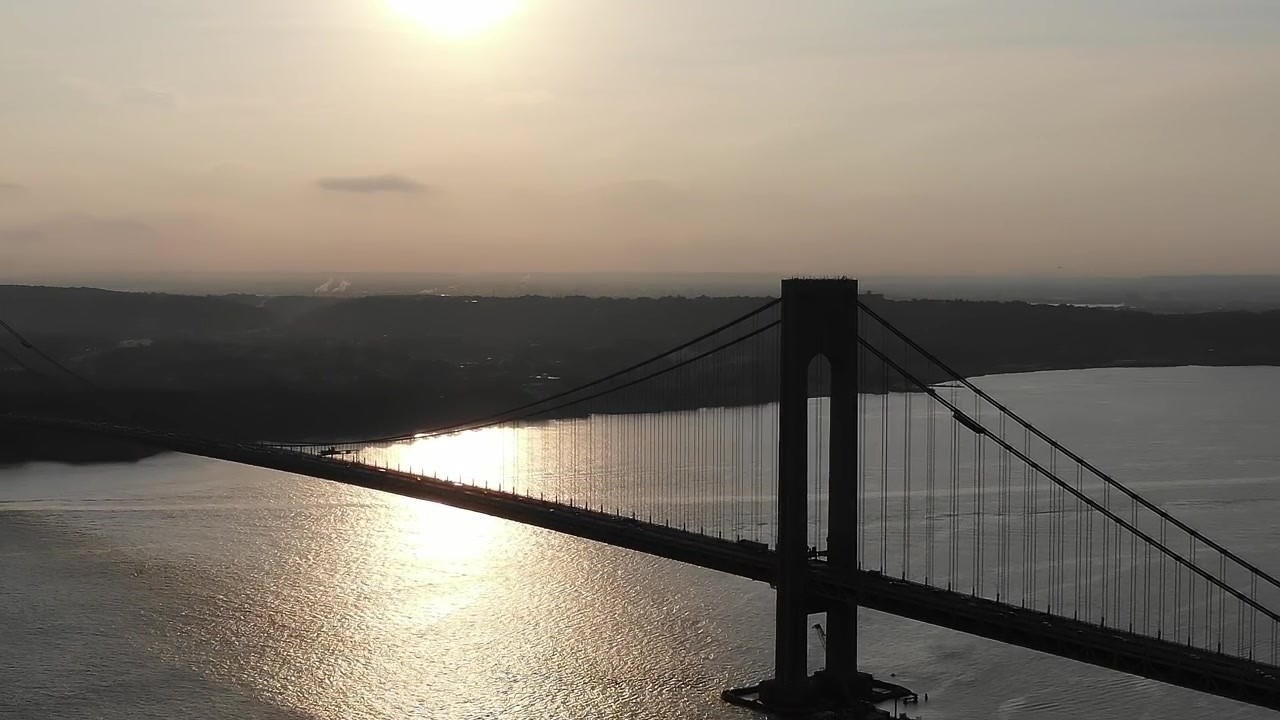 Vista del tramonto sul ponte a New York City, sull'acqua.
