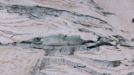 valmalenco, italy - the thick ice enveloping the surface of the fellaria glacier - aerial drone shot