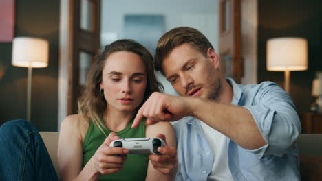 skilful gamer teaching play woman at videogame pov. focused lady holding gamepad