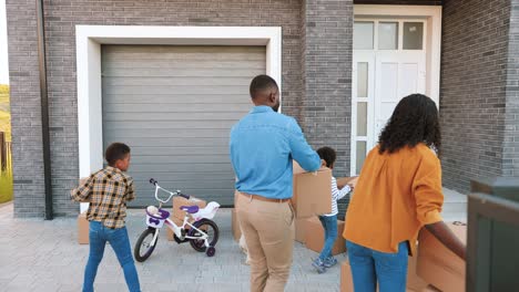 familia afroamericana feliz con niños pequeños y perro mudándose a un nuevo hogar en las afueras