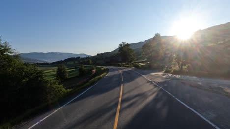 driving a car on a road in norway at dawn.