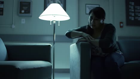 a solemn moment in a dimly lit room: reflecting on thoughts and emotions beneath a soft lamp glow