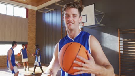 Portrait-of-caucasian-male-basketball-player-with-team-in-background