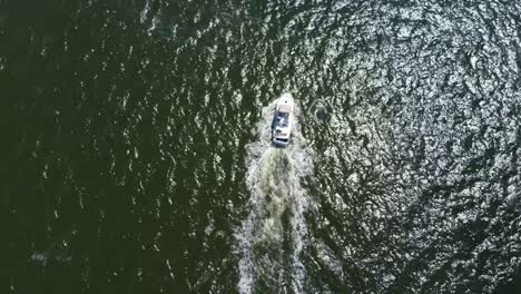 Birds-eye-view-straight-down-of-a-drone-following-a-motor-boat