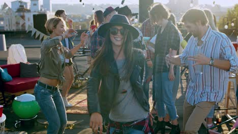 Beautiful-Stylish-Youg-Girl-In-A-Hat-And-Dark-Sunglasses-Dancing-Joyfully-At-The-Rooftop-Party
