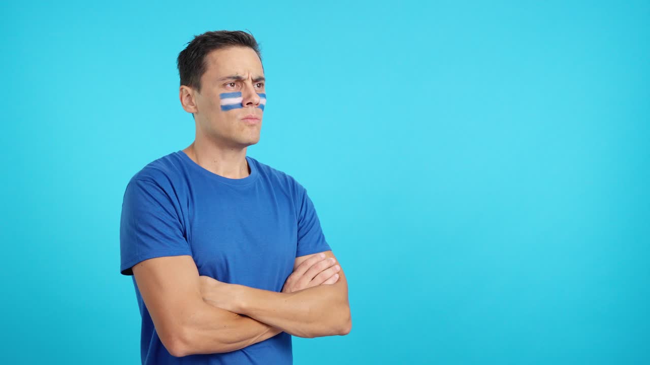 Man with salvadoran flag painted looking away with serious expression
