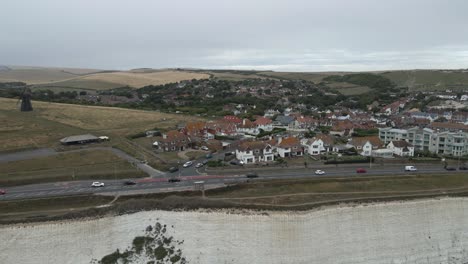 aerial: steep white chalk cliffs of seaside rottingdean, brighton, uk